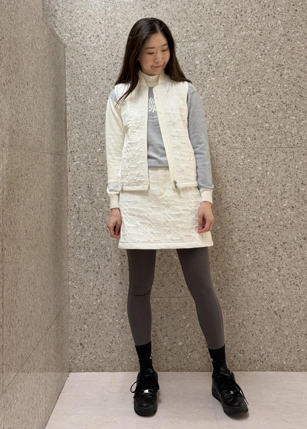 ホワイト系のTシャツ/カットソー、ホワイト系のブルゾン、グレー系のニット/セーターを着用したレディースの秋コーディネートの6枚目の写真