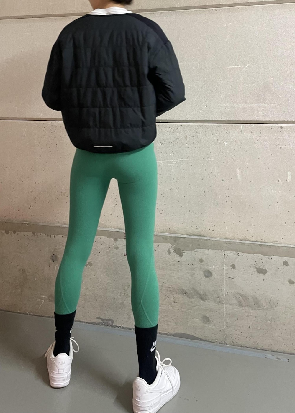 ホワイト系のスニーカー、ブラック系のブルゾン、グレー系のスウェットを着用したレディースの冬コーディネートの3枚目の写真