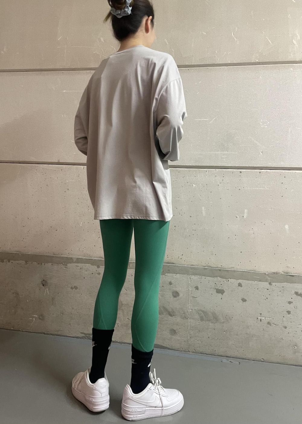 ホワイト系のスニーカー、グレー系のTシャツ/カットソー、グリーン系のレギンス/スパッツを着用したレディースの冬コーディネートの4枚目の写真