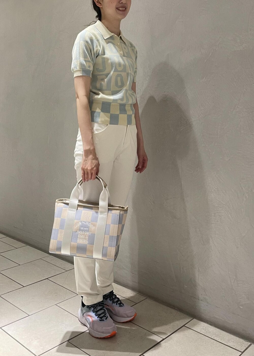 ブルー系のニット/セーター、ブルー系のトートバッグ、ホワイト系のその他パンツを着用したレディースの夏コーディネートの2枚目の写真