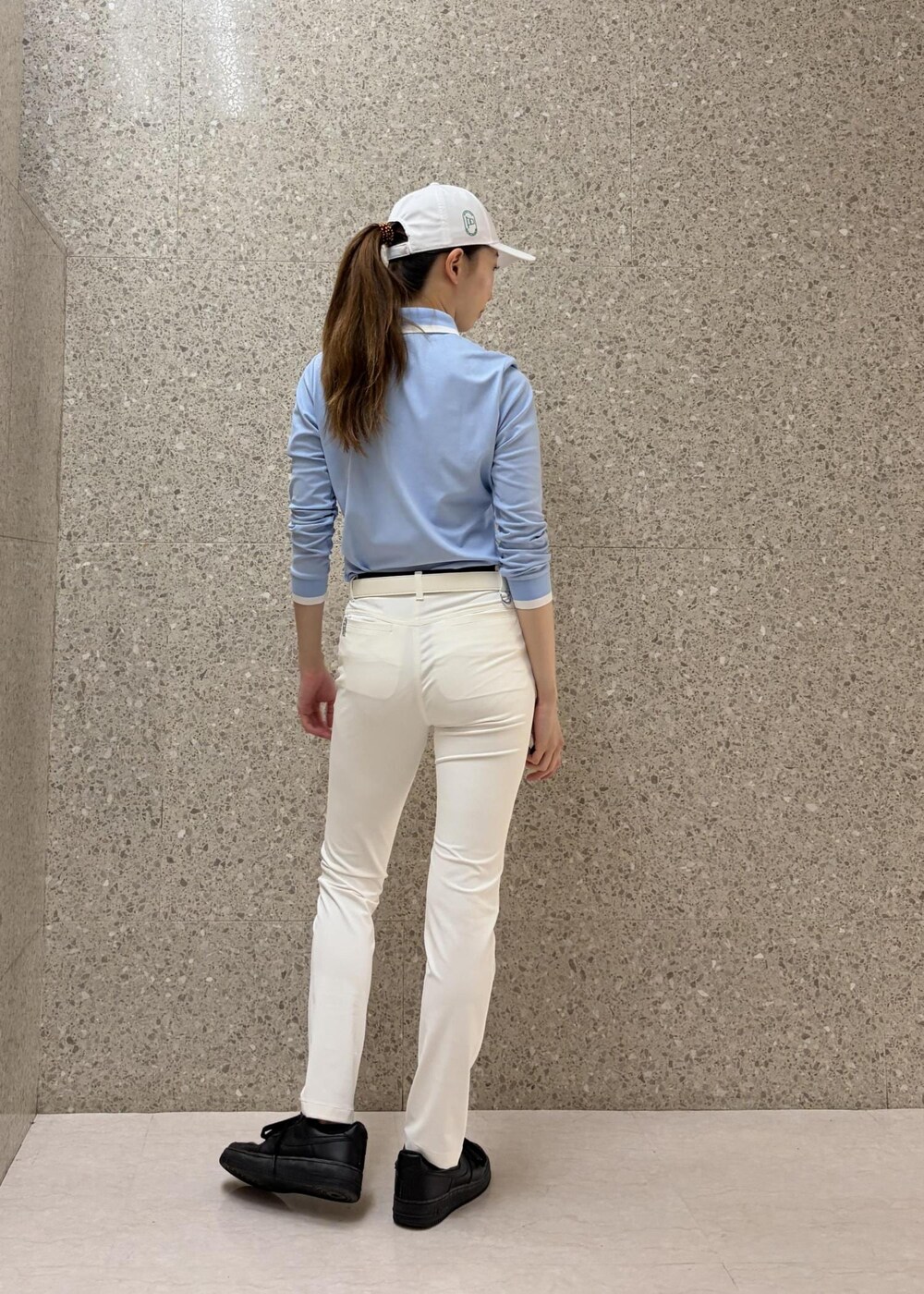 ブルー系のポロシャツ、ホワイト系のその他パンツ、ホワイト系のベルトを着用したレディースの秋コーディネートの3枚目の写真
