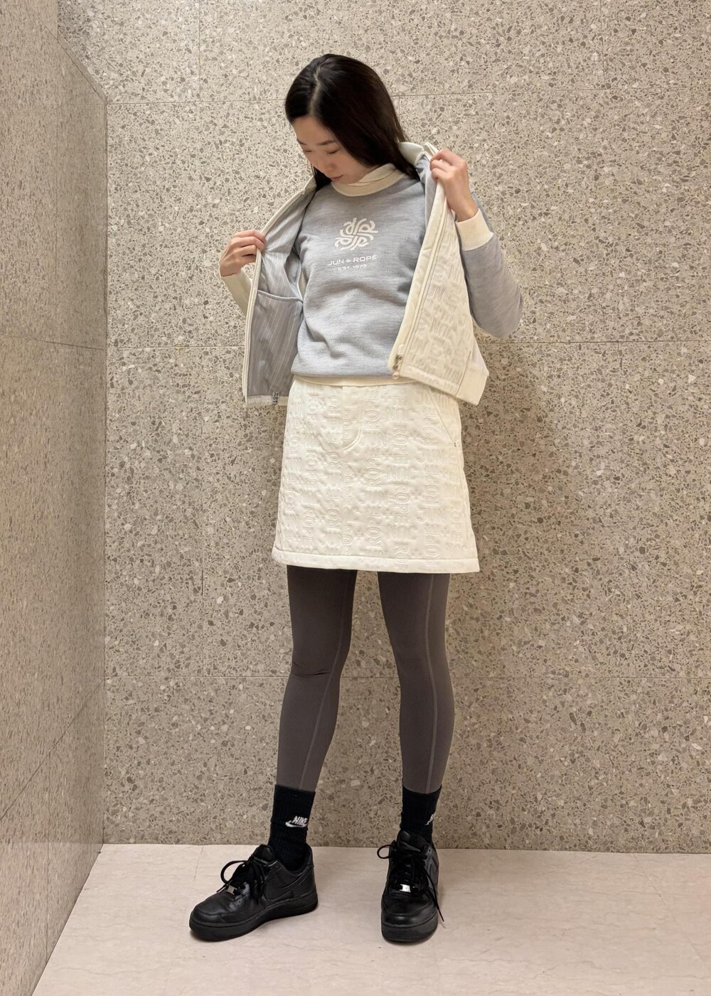 ホワイト系のTシャツ/カットソー、ホワイト系のブルゾン、グレー系のニット/セーターを着用したレディースの秋コーディネートの2枚目の写真