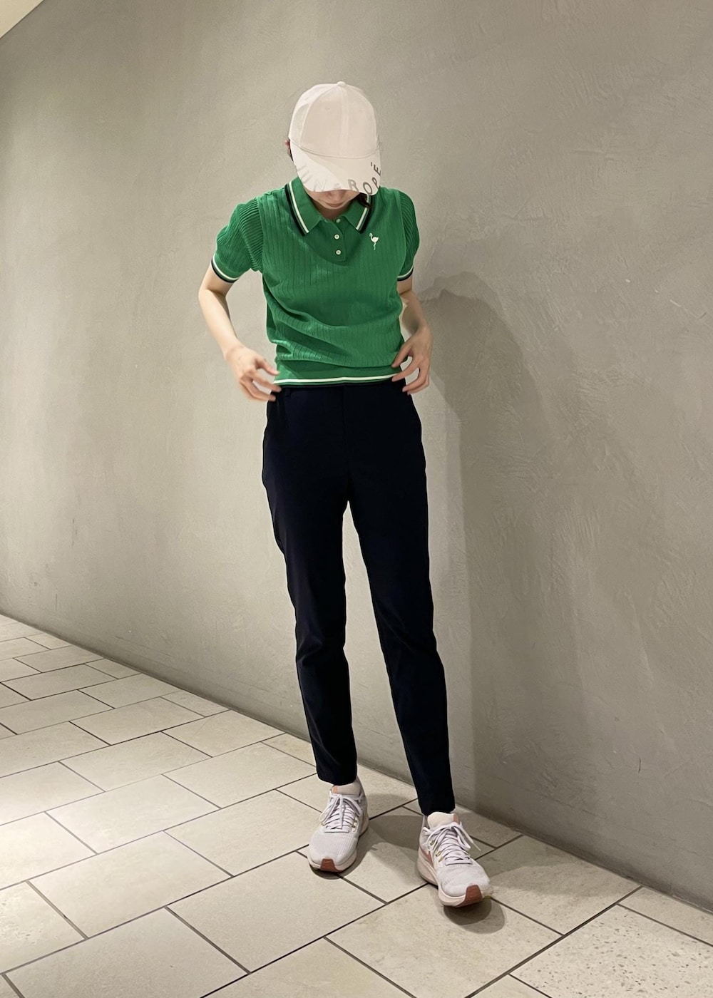 グリーン系のポロシャツ、ブルー系のその他パンツ、ホワイト系のキャップを着用したレディースの夏コーディネートの5枚目の写真