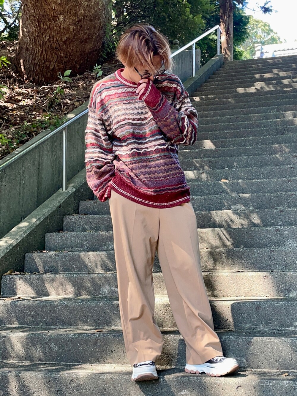 ブラック系のスニーカー、ベージュ系のスラックスを着用したメンズの秋コーディネートの2枚目の写真