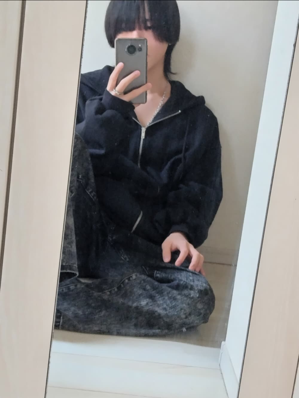 ブラック系のパーカー、ブラック系のデニムパンツ、シルバー系のネックレスを着用したメンズの春コーディネートの2枚目の写真