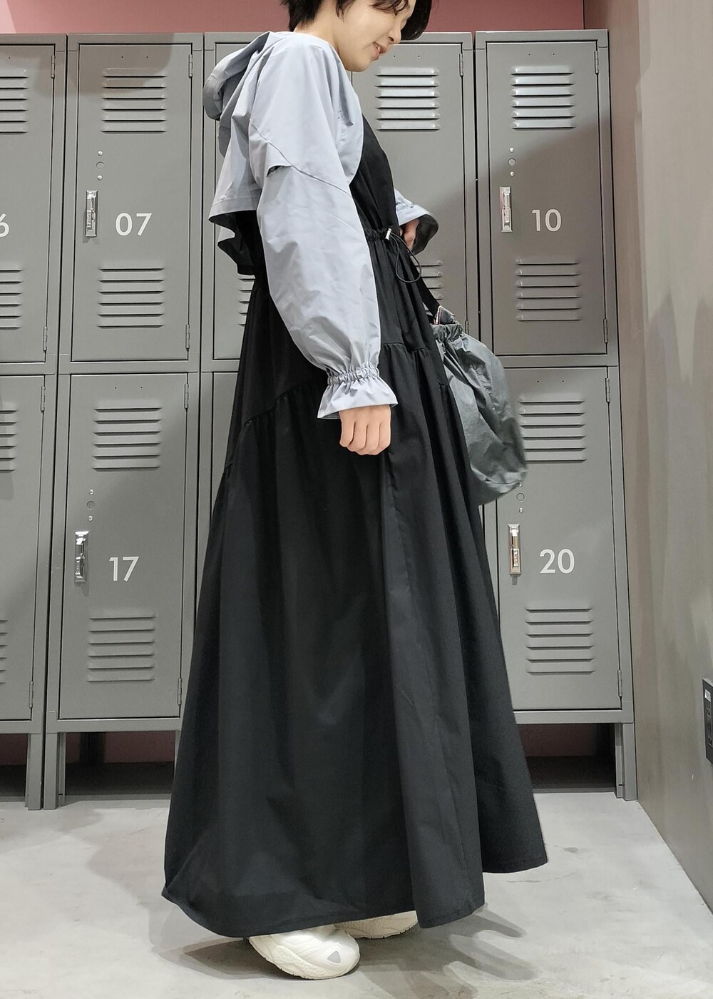 ベージュ系のスニーカー、ブラック系のワンピースを着用したレディースの春コーディネートの2枚目の写真