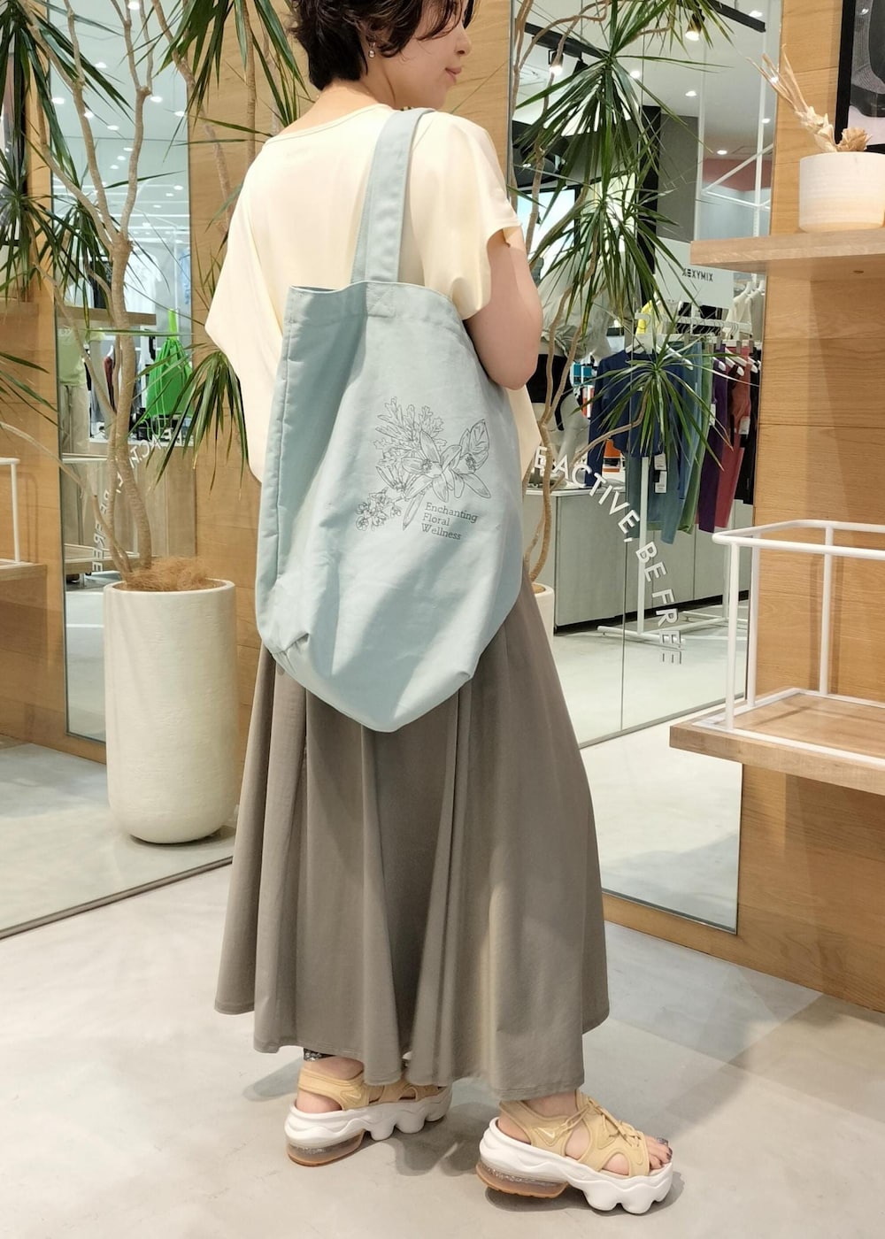 ベージュ系のサンダル、グリーン系のスカート、ベージュ系のTシャツ/カットソーを着用したレディースの夏コーディネートの2枚目の写真