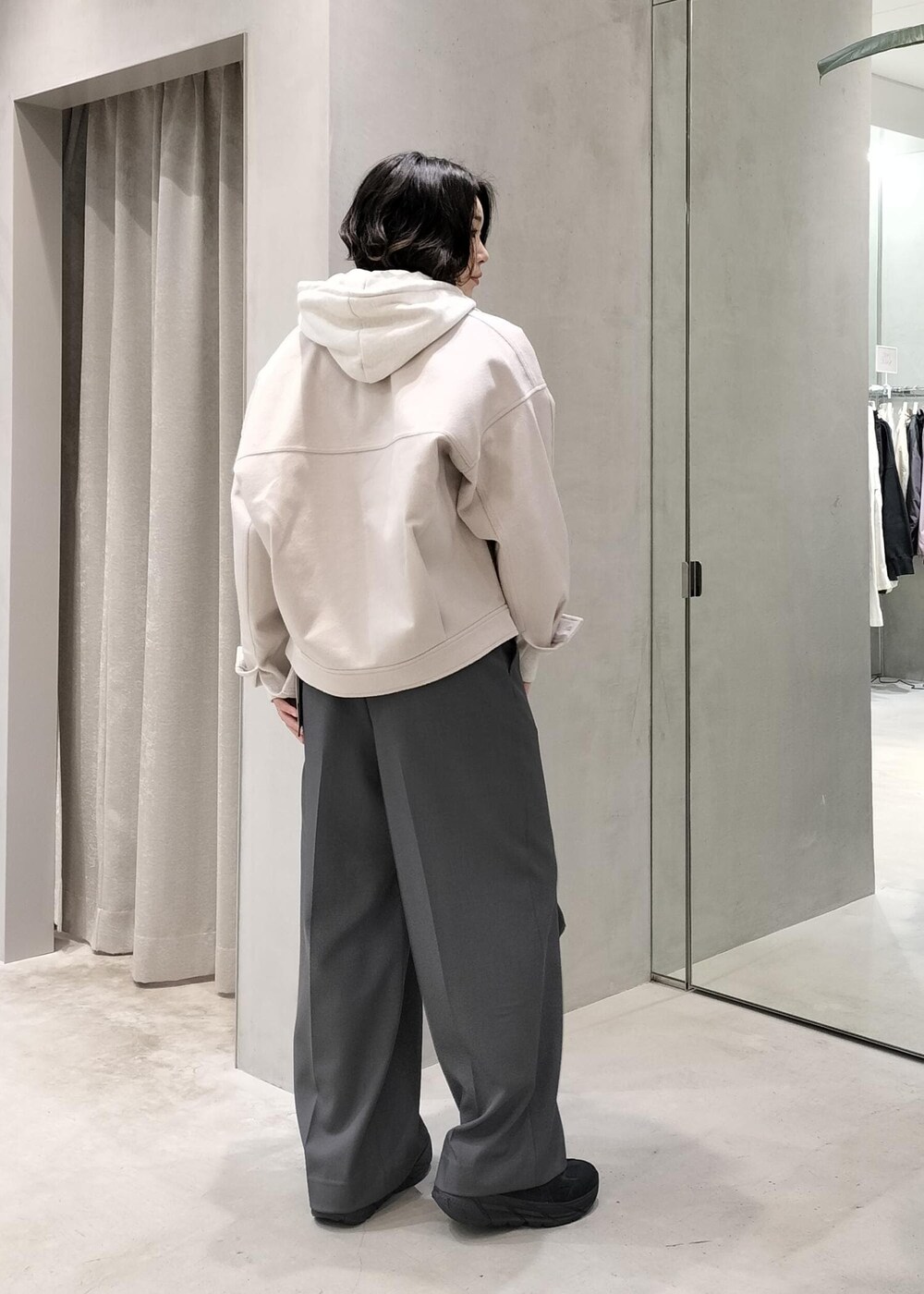 ベージュ系のその他アウター、グレー系のスラックス、ホワイト系のパーカーを着用したレディースの冬コーディネートの2枚目の写真