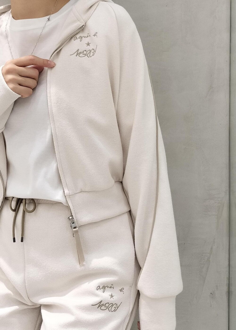 ベージュ系のスニーカー、ホワイト系のその他パンツ、ホワイト系のパーカーを着用したレディースの夏コーディネートの4枚目の写真