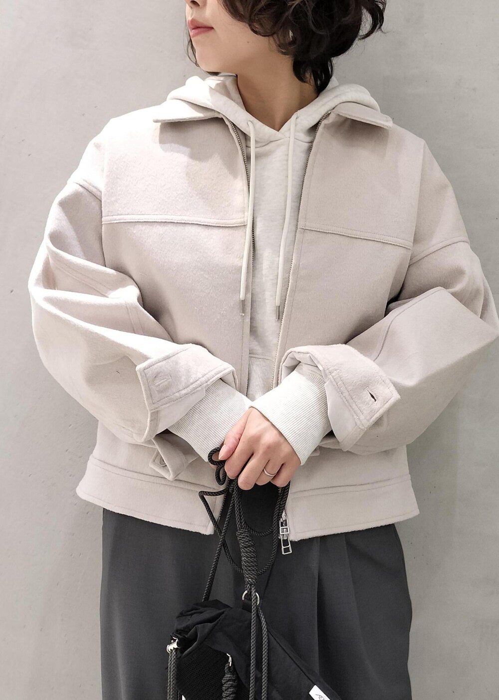 ベージュ系のその他アウター、グレー系のスラックス、ホワイト系のパーカーを着用したレディースの冬コーディネートの6枚目の写真