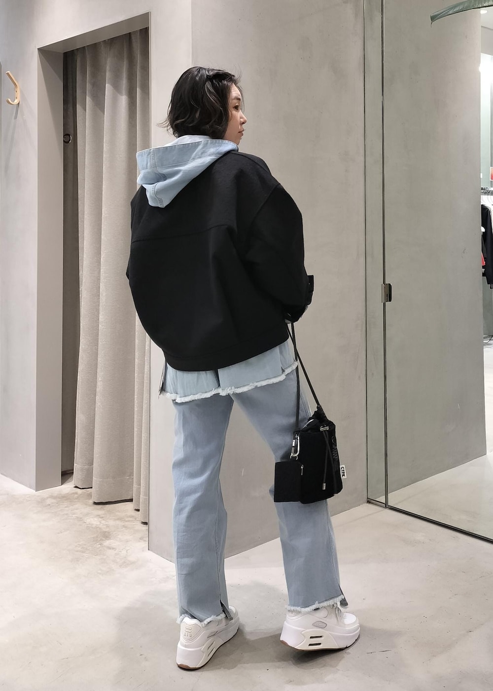 ブルー系のデニムパンツ、ブルー系のパーカー、ホワイト系のTシャツ/カットソーを着用したレディースの冬コーディネートの2枚目の写真