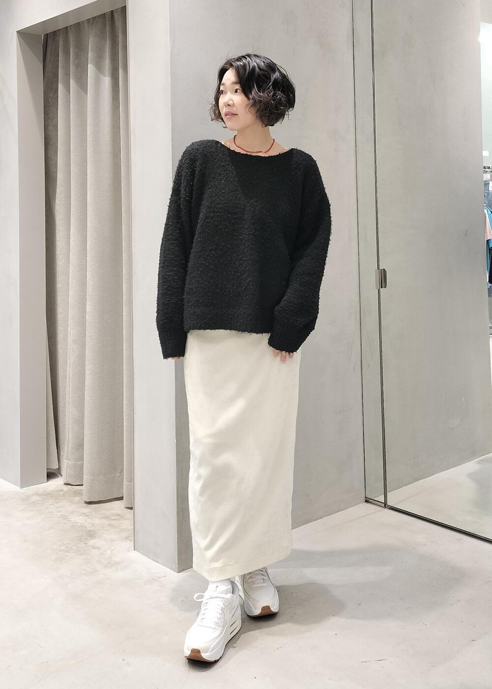 ホワイト系のスカート、ホワイト系のキャミソール、ブラック系のニット/セーターを着用したレディースの冬コーディネートの5枚目の写真