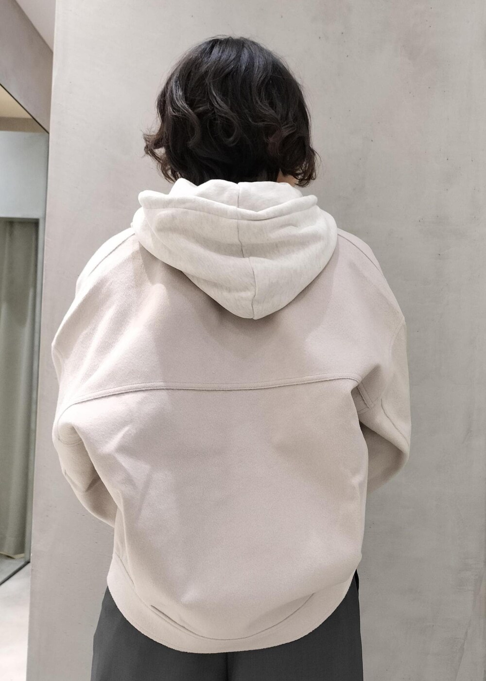 ベージュ系のその他アウター、グレー系のスラックス、ホワイト系のパーカーを着用したレディースの冬コーディネートの7枚目の写真