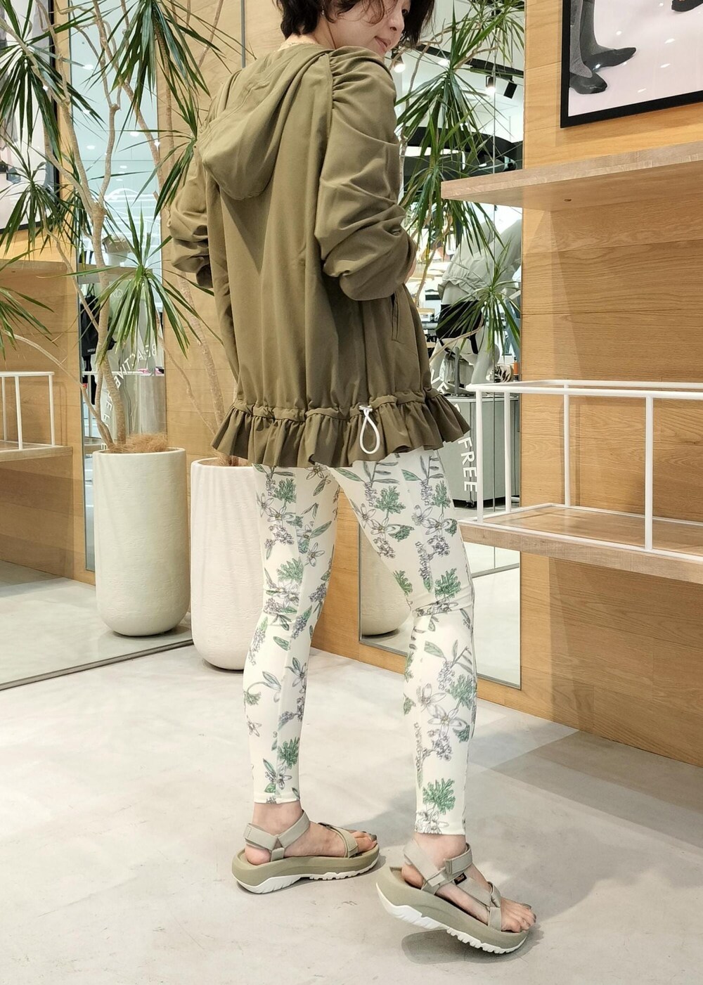 グリーン系のサンダル、グリーン系のパーカー、ベージュ系のレギンス/スパッツを着用したレディースの夏コーディネートの2枚目の写真