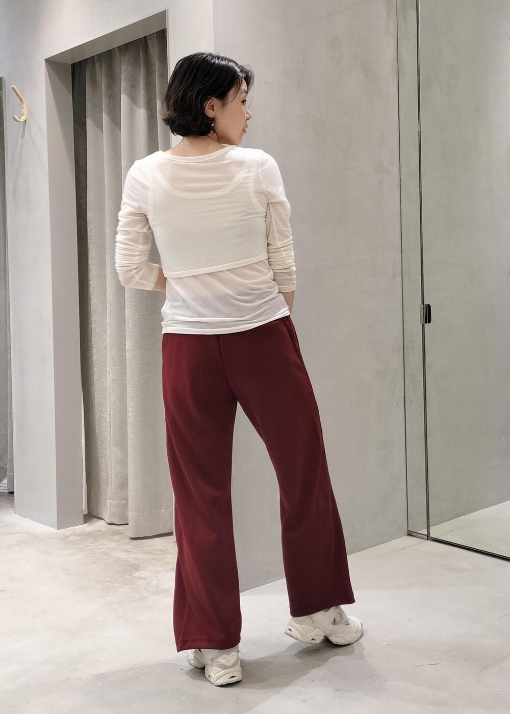 ベージュ系のスニーカー、ブラック系のトートバッグ、レッド系のその他パンツを着用したレディースの秋コーディネートの3枚目の写真