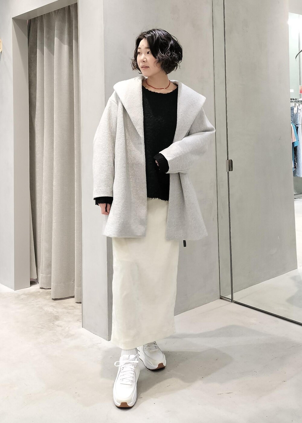 ホワイト系のスカート、ホワイト系のキャミソール、ブラック系のニット/セーターを着用したレディースの冬コーディネートの4枚目の写真