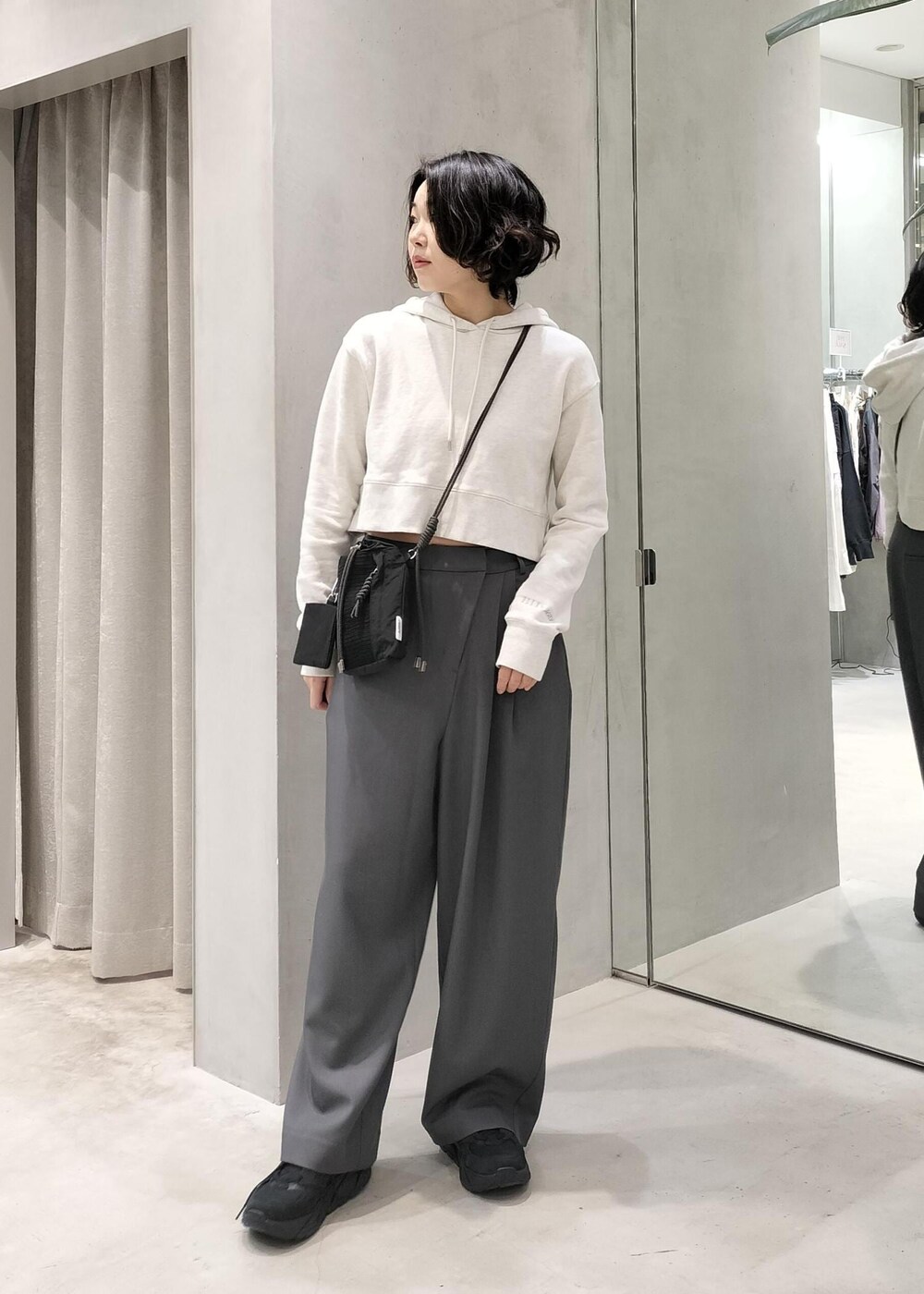 ベージュ系のその他アウター、グレー系のスラックス、ホワイト系のパーカーを着用したレディースの冬コーディネートの3枚目の写真