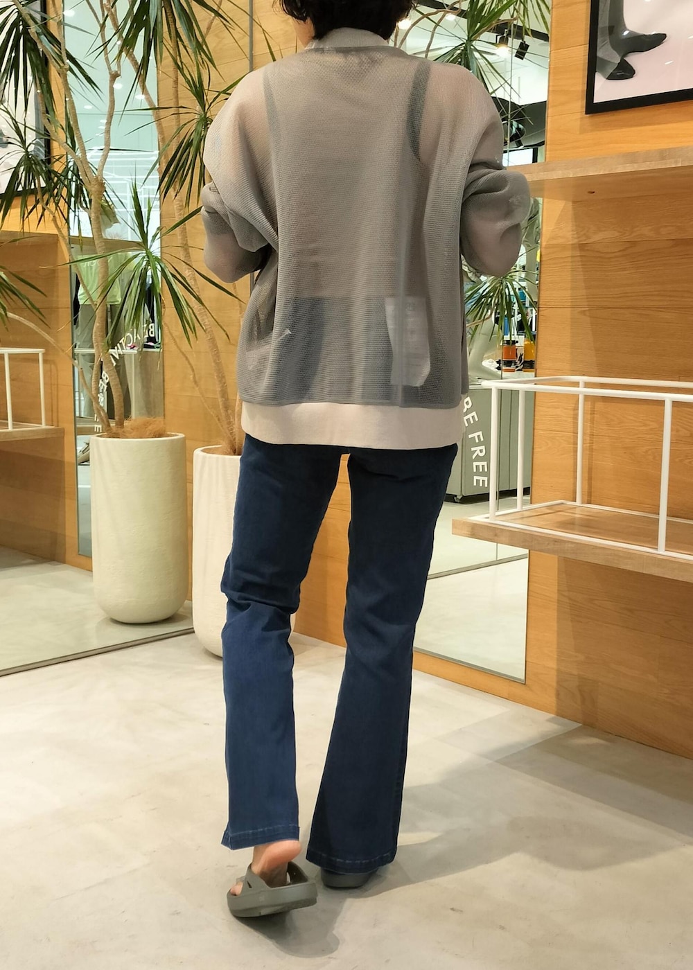 グレー系のカーディガン/ボレロ、グリーン系のサンダル、ブルー系のデニムパンツを着用したレディースの夏コーディネートの3枚目の写真
