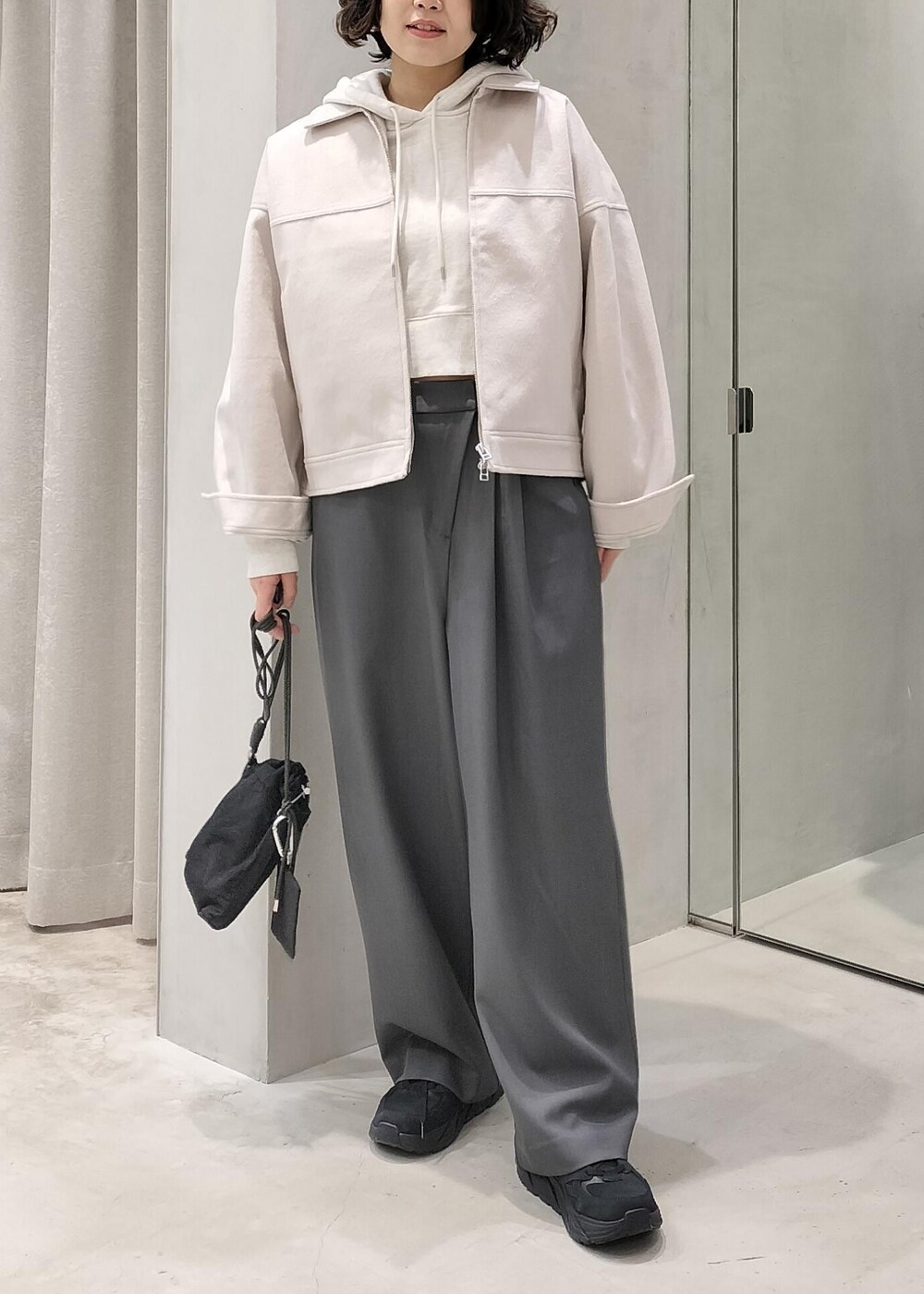 ベージュ系のその他アウター、グレー系のスラックス、ホワイト系のパーカーを着用したレディースの冬コーディネートの5枚目の写真