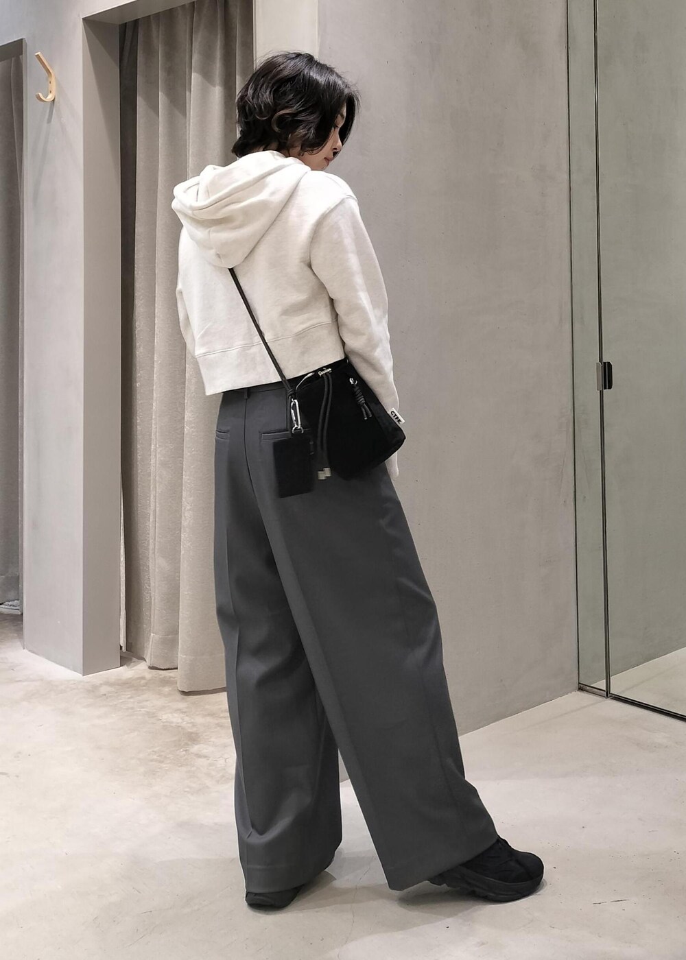 ベージュ系のその他アウター、グレー系のスラックス、ホワイト系のパーカーを着用したレディースの冬コーディネートの4枚目の写真