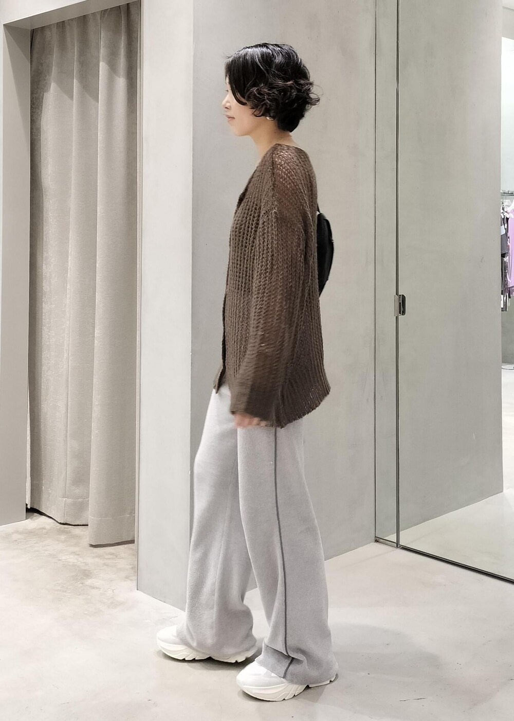 グレー系のキャミソール、ブラウン系のカーディガン/ボレロ、ブラック系のボディバッグ/ウエストポーチを着用したレディースの秋コーディネートの2枚目の写真