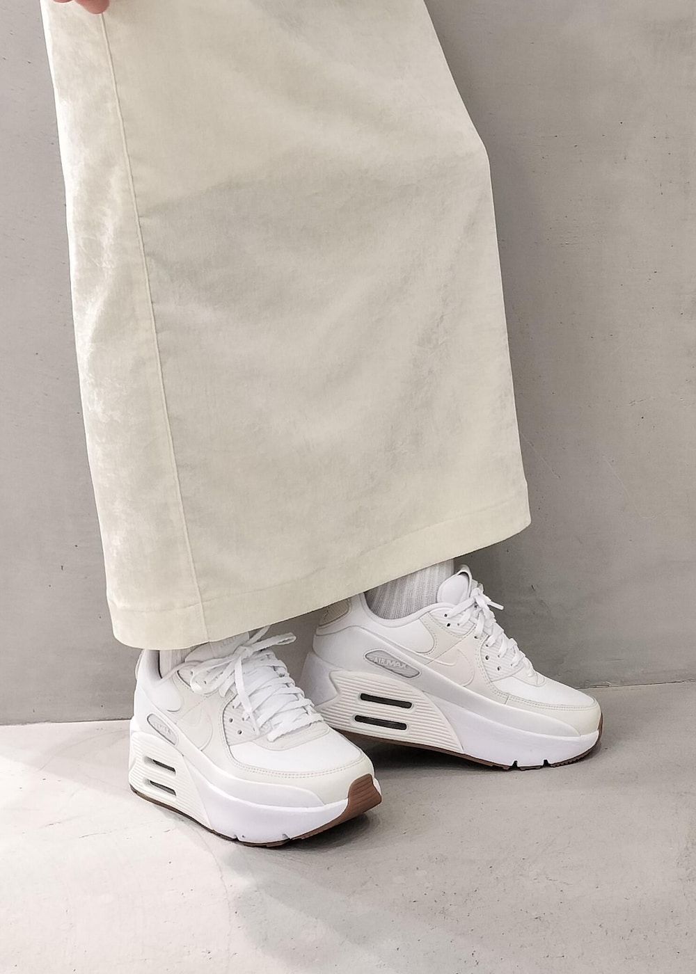 ホワイト系のスカート、ホワイト系のキャミソール、ブラック系のニット/セーターを着用したレディースの冬コーディネートの7枚目の写真