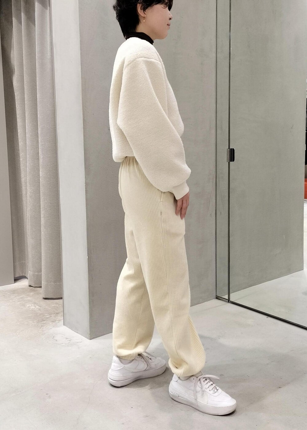 ホワイト系のスニーカー、ホワイト系のその他パンツ、ホワイト系のその他トップスを着用したレディースの冬コーディネートの2枚目の写真