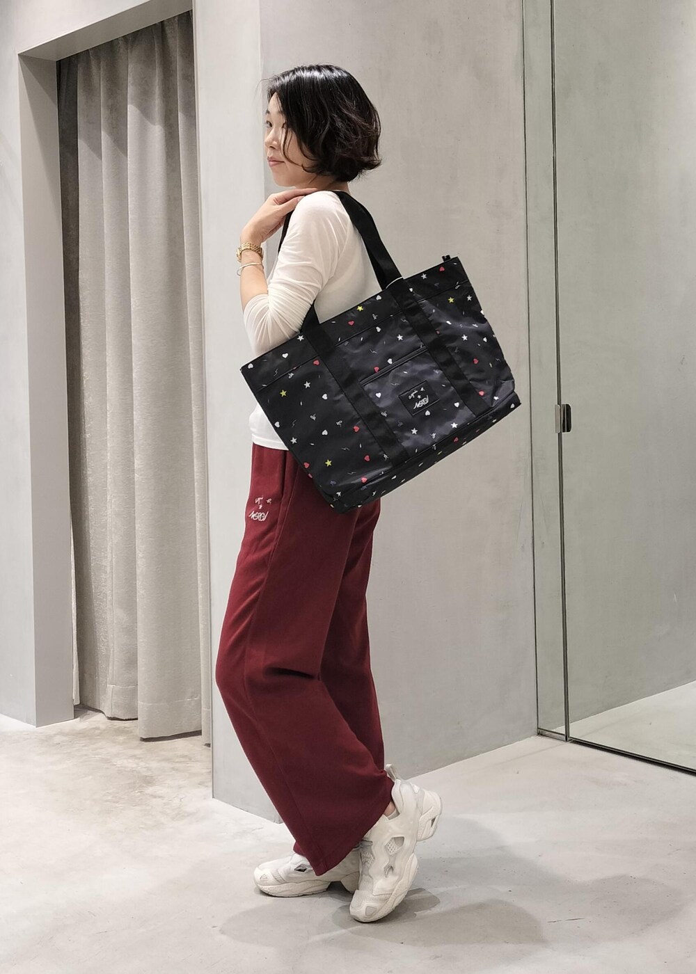 ベージュ系のスニーカー、ブラック系のトートバッグ、レッド系のその他パンツを着用したレディースの秋コーディネートの5枚目の写真