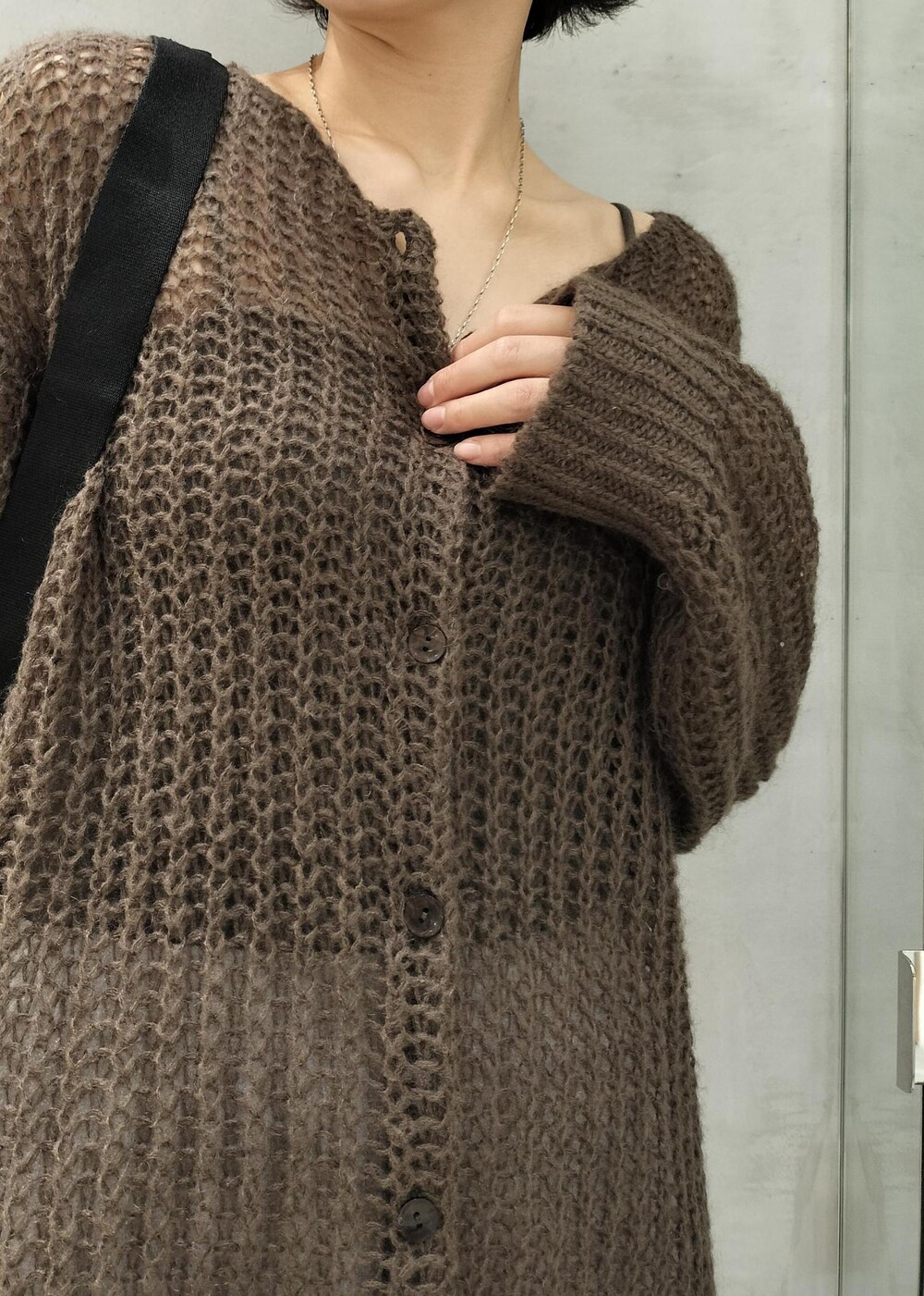 グレー系のキャミソール、ブラウン系のカーディガン/ボレロ、ブラック系のボディバッグ/ウエストポーチを着用したレディースの秋コーディネートの4枚目の写真