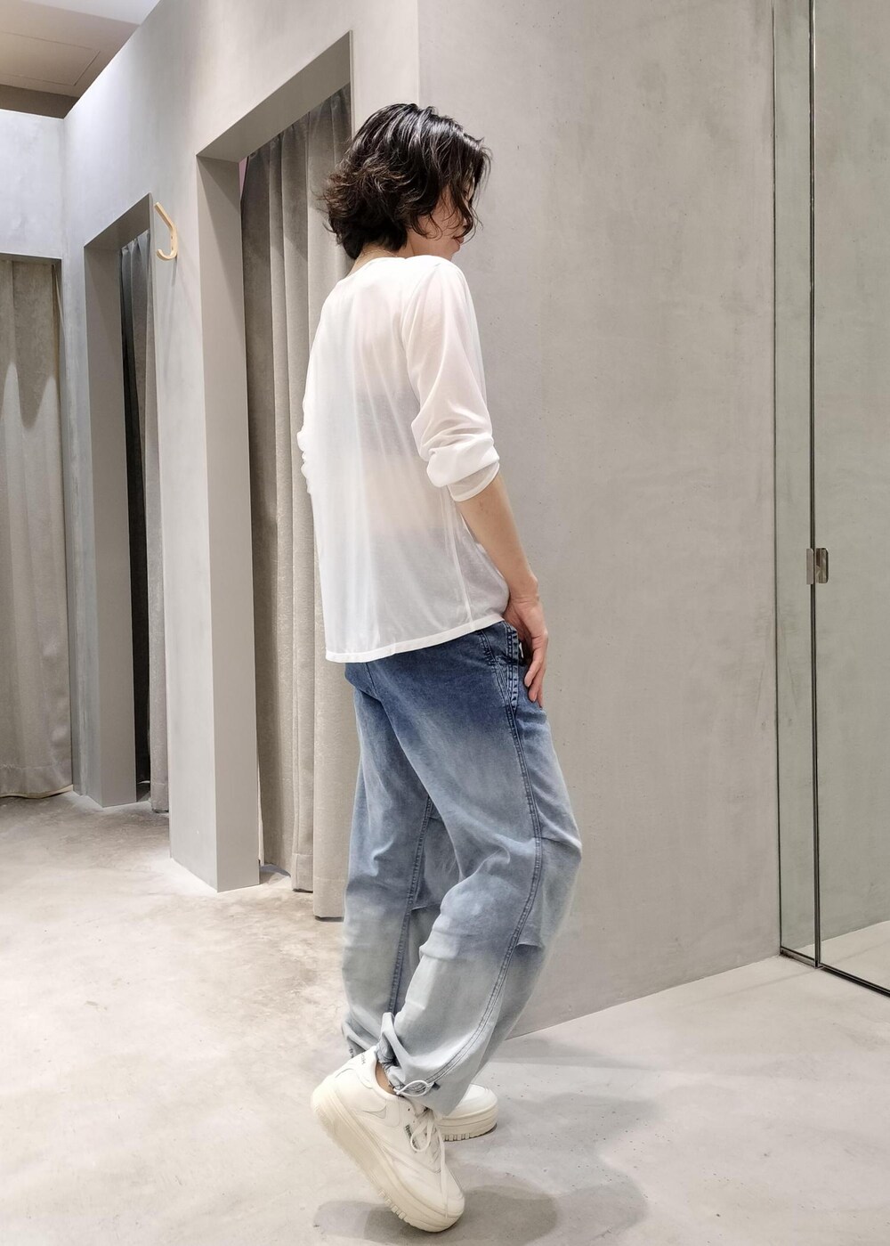 ホワイト系のスニーカー、ブルー系のデニムパンツ、ホワイト系のTシャツ/カットソーを着用したレディースの夏コーディネートの2枚目の写真