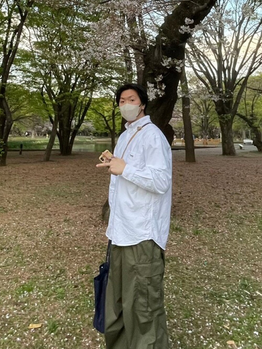 ホワイト系のシャツ/ブラウス、ブラウン系のショルダーバッグ、グリーン系のカーゴパンツを着用したメンズの春コーディネートの2枚目の写真