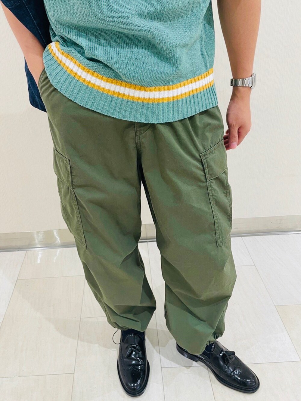 グリーン系のカーゴパンツ、ブラック系のその他シューズ、ブルー系のトートバッグを着用したメンズの秋コーディネートの3枚目の写真