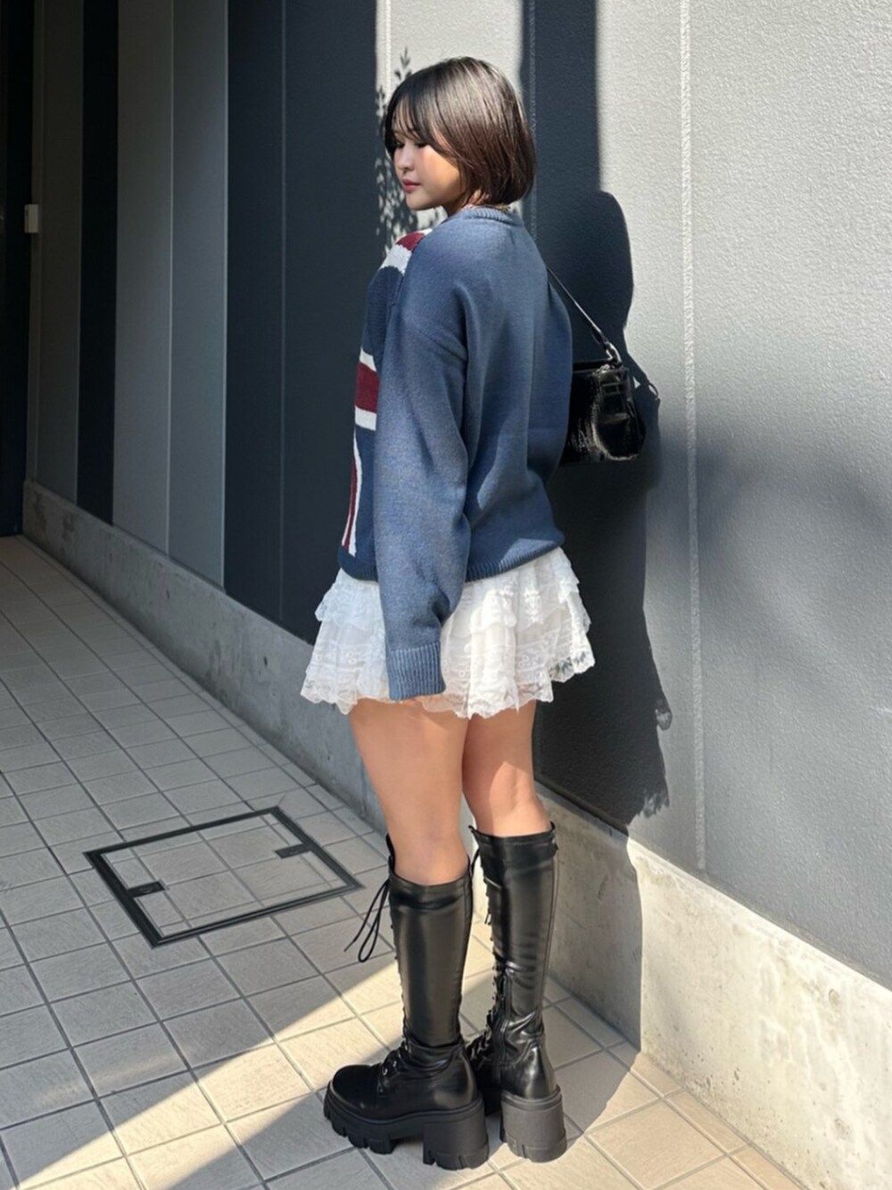 ブラック系のブーツ、ブルー系のニット/セーター、ホワイト系のその他パンツを着用したレディースの冬コーディネートの3枚目の写真