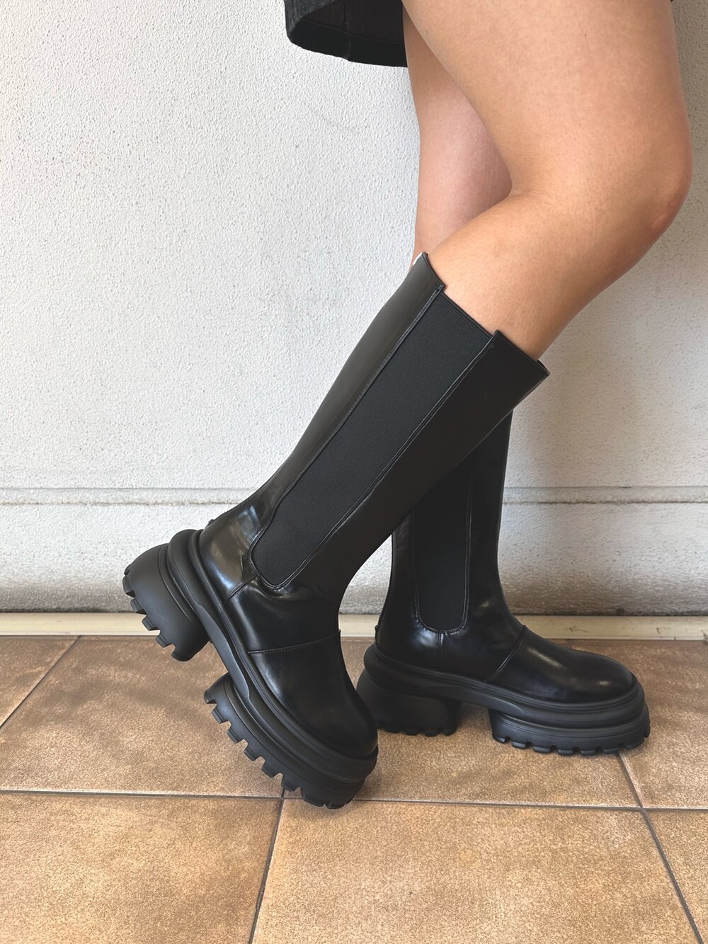 ブラック系のニット/セーター、ブラック系のワンピース、ブラック系のハンドバッグを着用したレディースの秋コーディネートの8枚目の写真