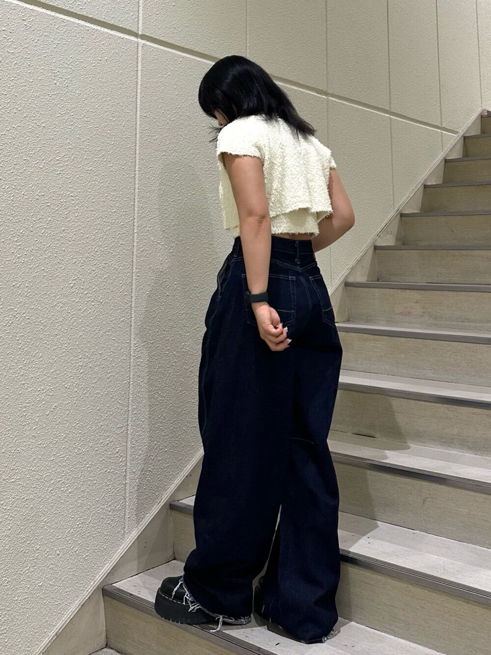 ブラック系のアンサンブル、ブルー系のデニムパンツを着用したレディースの夏コーディネートの4枚目の写真