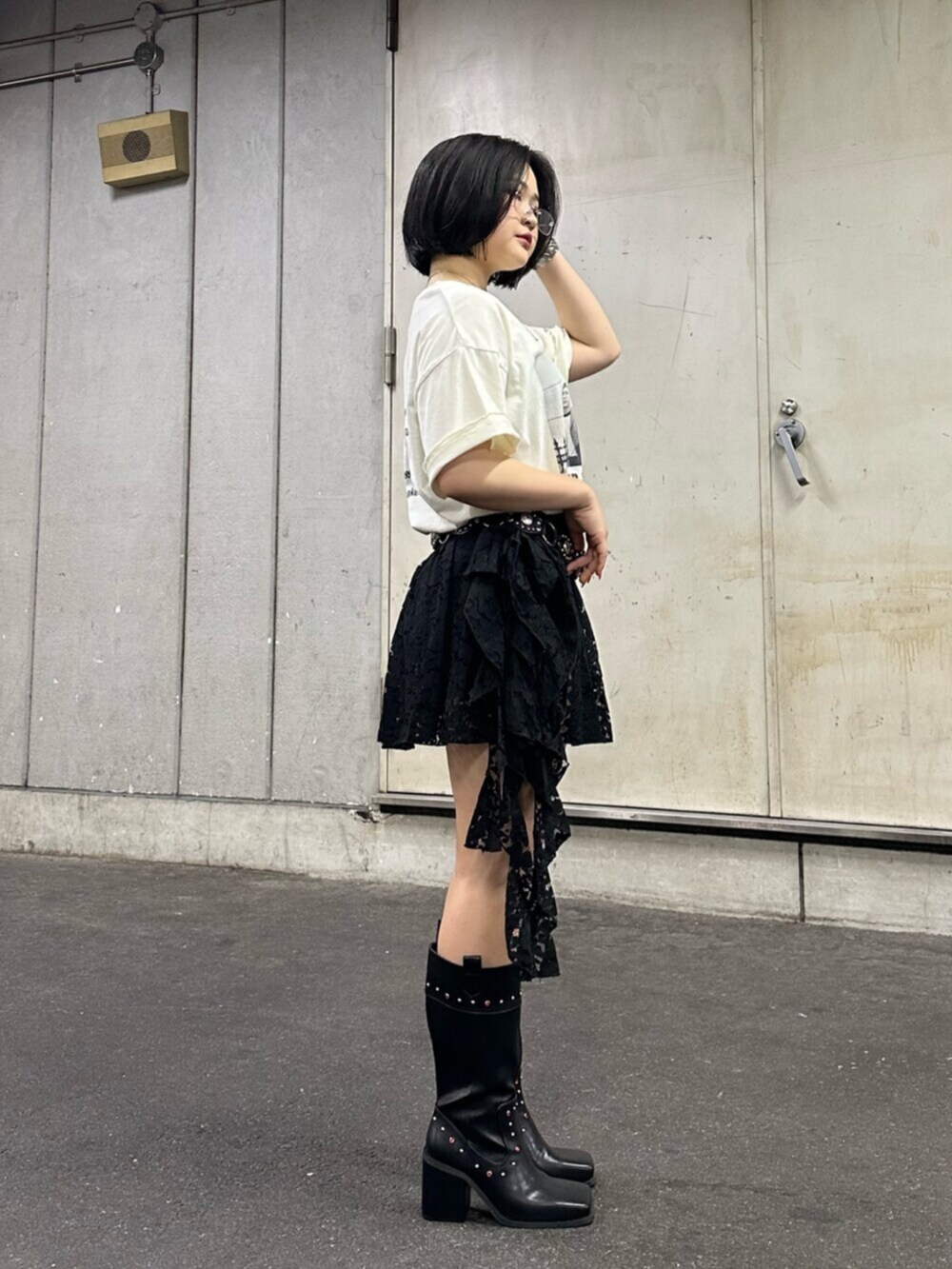 ブラック系のブーツ、ホワイト系のTシャツ/カットソー、ブラック系のスカートを着用したレディースの夏コーディネートの3枚目の写真