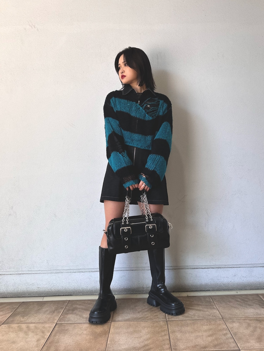 ブラック系のニット/セーター、ブラック系のワンピース、ブラック系のハンドバッグを着用したレディースの秋コーディネートの2枚目の写真