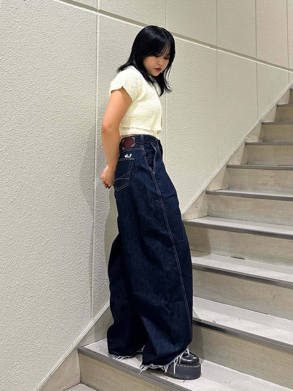 ブラック系のアンサンブル、ブルー系のデニムパンツを着用したレディースの夏コーディネートの3枚目の写真