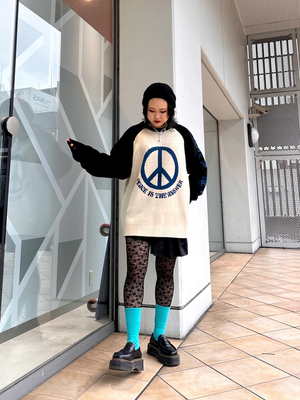 ホワイト系のニット/セーター、ブラック系のスカート、シルバー系のネックレスを着用したレディースの冬コーディネートの2枚目の写真