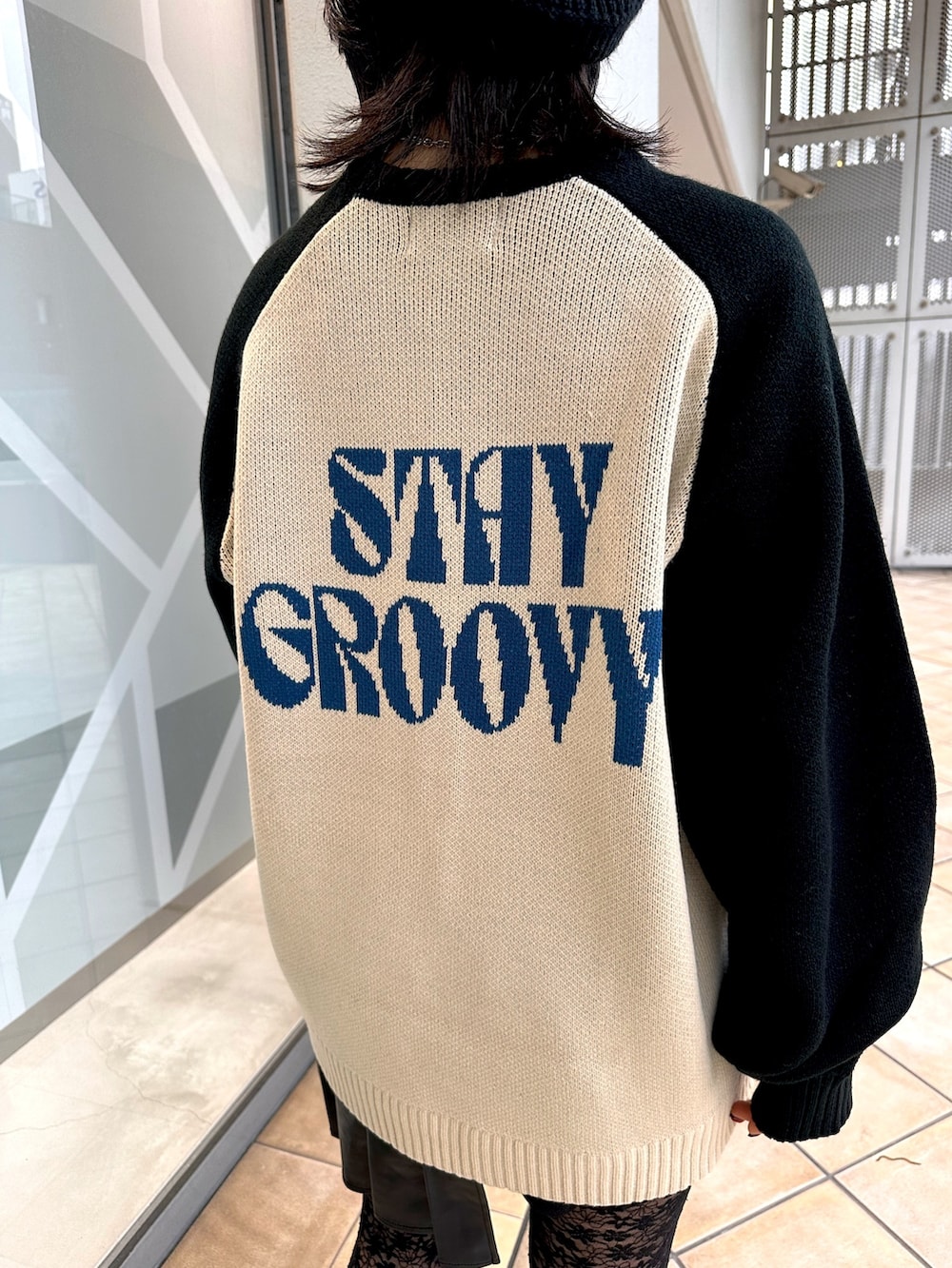 ホワイト系のニット/セーター、ブラック系のスカート、シルバー系のネックレスを着用したレディースの冬コーディネートの6枚目の写真