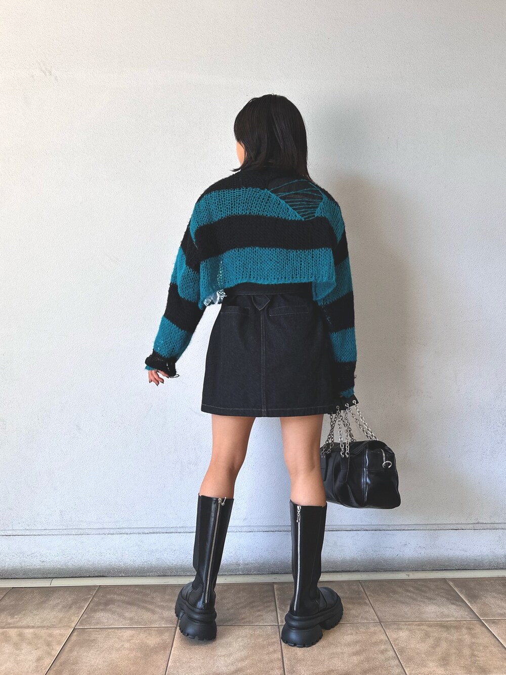 ブラック系のニット/セーター、ブラック系のワンピース、ブラック系のハンドバッグを着用したレディースの秋コーディネートの4枚目の写真