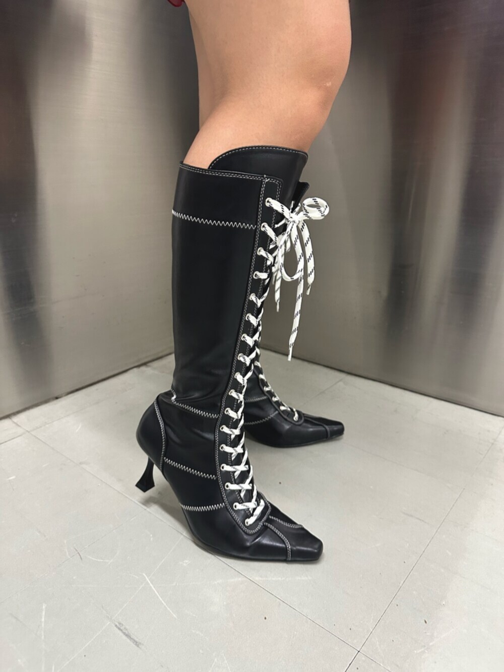 ホワイト系のシャツ/ブラウス、ブラック系のパーカー、レッド系のスカートを着用したレディースの秋コーディネートの7枚目の写真