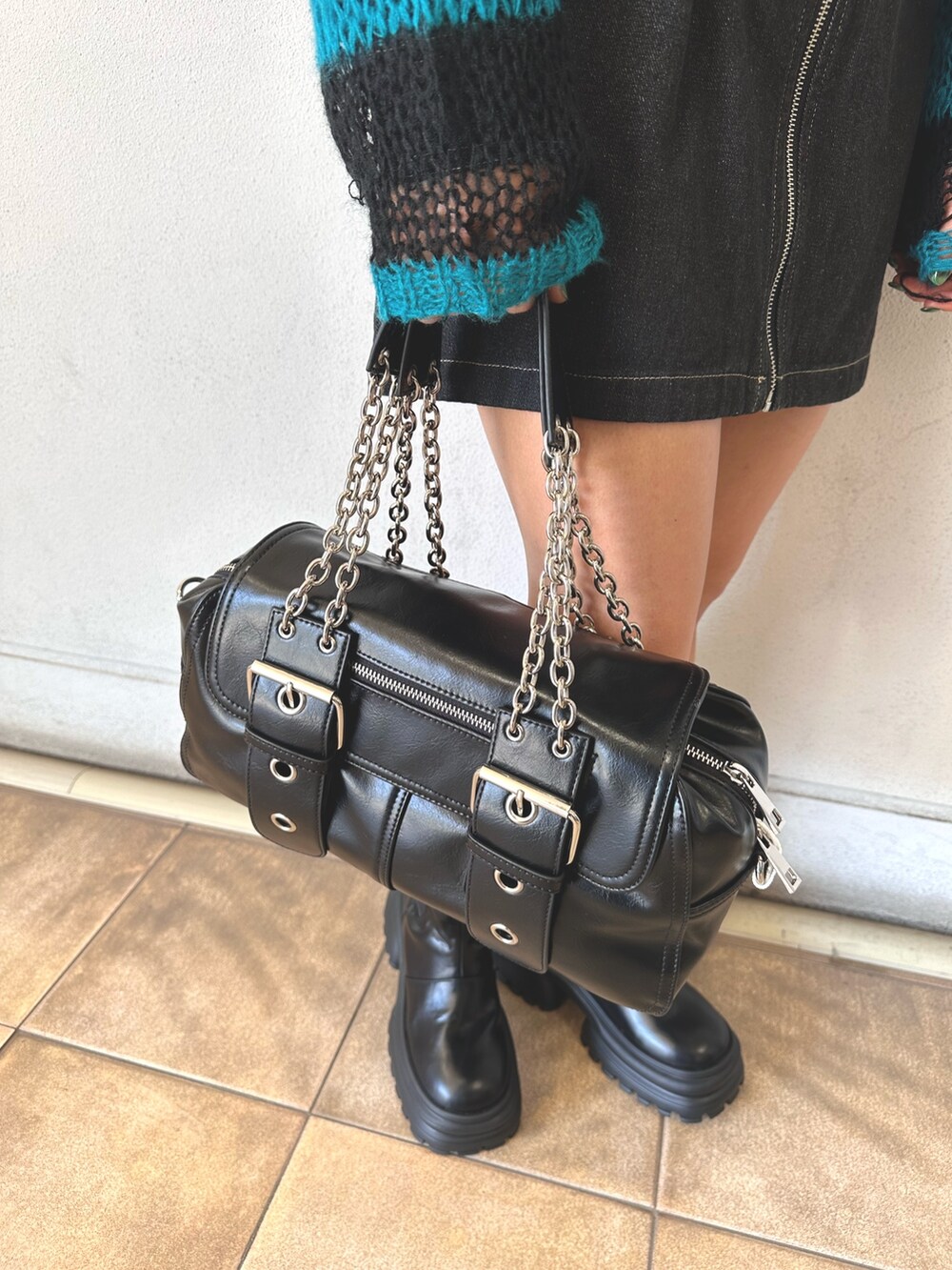 ブラック系のニット/セーター、ブラック系のワンピース、ブラック系のハンドバッグを着用したレディースの秋コーディネートの5枚目の写真