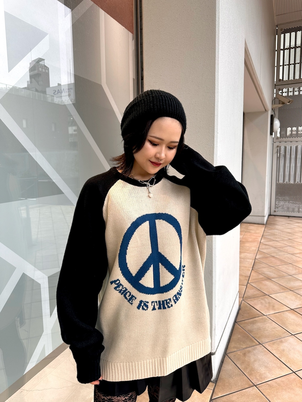 ホワイト系のニット/セーター、ブラック系のスカート、シルバー系のネックレスを着用したレディースの冬コーディネートの4枚目の写真