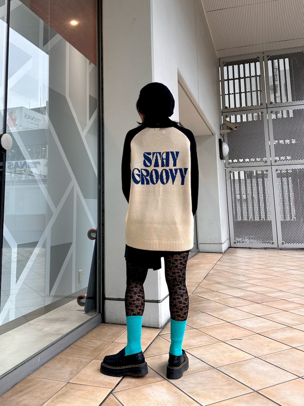 ホワイト系のニット/セーター、ブラック系のスカート、シルバー系のネックレスを着用したレディースの冬コーディネートの3枚目の写真