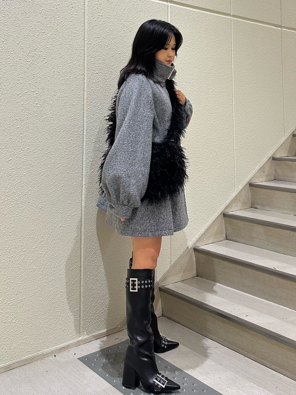 グレー系のその他アウター、ブラック系のショルダーバッグ、ブラック系のブーツを着用したレディースの秋コーディネートの2枚目の写真