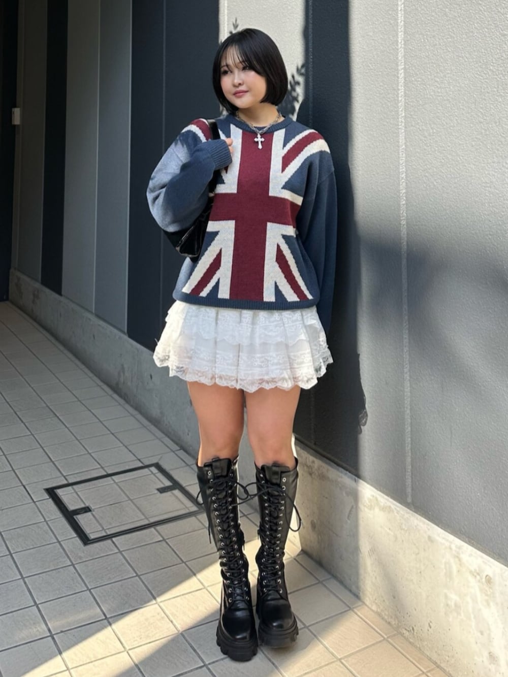 ブラック系のブーツ、ブルー系のニット/セーター、ホワイト系のその他パンツを着用したレディースの冬コーディネートの2枚目の写真