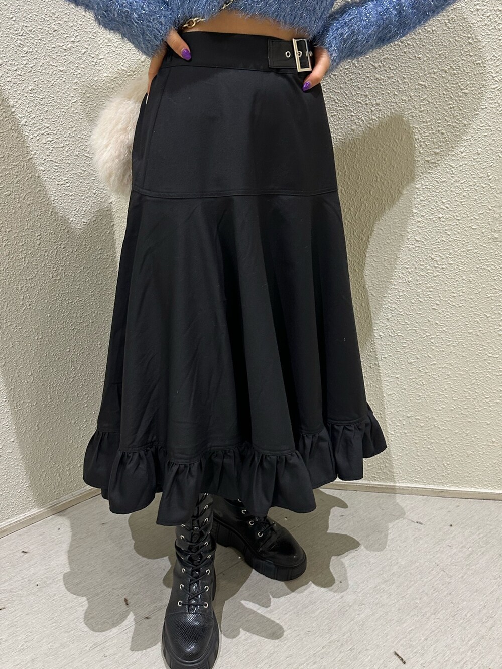 ブラック系のスカート、ホワイト系のハンドバッグ、ブルー系のニット/セーターを着用したレディースの冬コーディネートの7枚目の写真