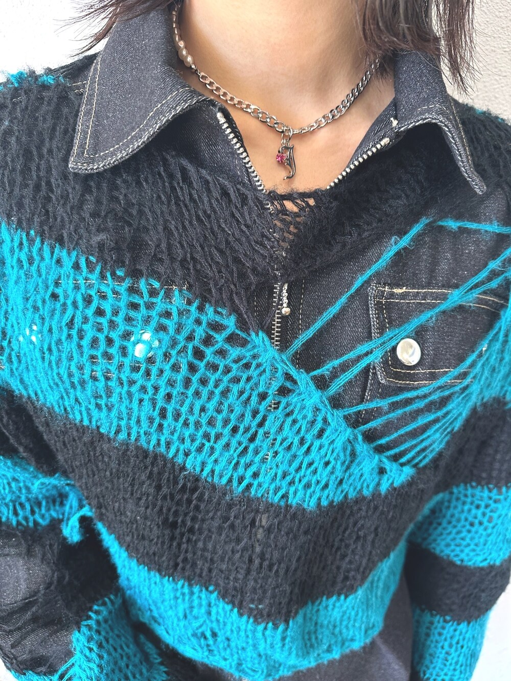 ブラック系のニット/セーター、ブラック系のワンピース、ブラック系のハンドバッグを着用したレディースの秋コーディネートの7枚目の写真