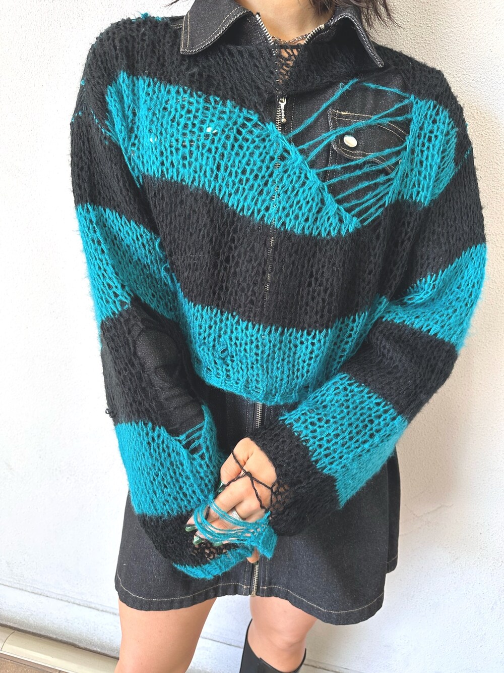 ブラック系のニット/セーター、ブラック系のワンピース、ブラック系のハンドバッグを着用したレディースの秋コーディネートの6枚目の写真